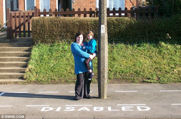 The most ludicrous parking bay in Britain: Rebecca Fairchild with son Joshua, who suffers from epilepsy and autism, in the bay with a lamppost in the middle 